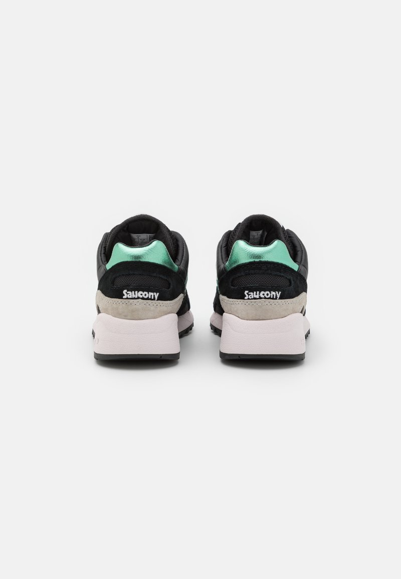 Schwarze und mintgrüne Sneaker mit Wildlederakzenten, runder Form und gepolstertem Schaft. Merkmale eine weiße Zwischensohle und eine strukturierte Gummisohle.