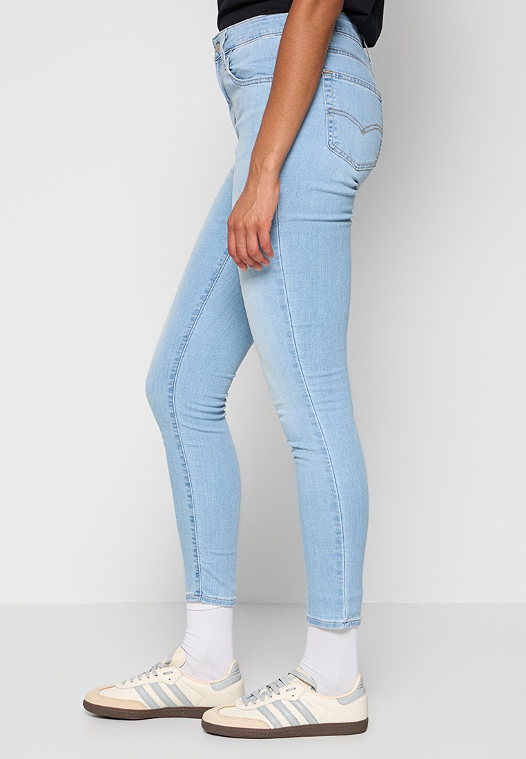 Hellblaue Skinny-Jeans aus Denim-Stoff mit glatter Textur, featuring einem klassischen Fünf-Taschen-Design und einem Reißverschluss. 