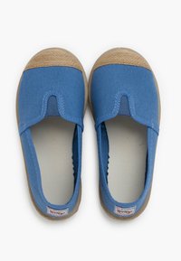 Scarpe slip-on in tela blu con suola in gomma beige e punta in juta testurizzata. Presentano una forma arrotondata e dettagli trapuntati attorno ai bordi.