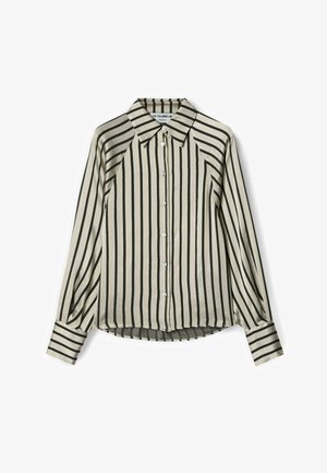 Camicia beige con bottoni, strisce verticali nere, maniche lunghe, colletto a punta e polsini a righe, stesa su sfondo bianco.