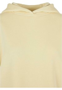 Kremowa bluza z kapturem o gładkim przodzie i miękkiej teksturze materiału, ukazująca górną część, w tym kaptur i dekolt.