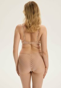 Beżowy zestaw stanika i majtek wykonany z gładkiego materiału, z regulowanymi ramiączkami oraz wzorem w zygzak na majtkach. Widok z tyłu z miękką, delikatną teksturą.