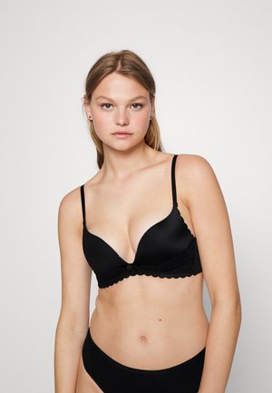 Black bra with a plunging neckline, lace accents, scalloped edges, and thin adjustable straps. Smooth fabric with a supportive design.