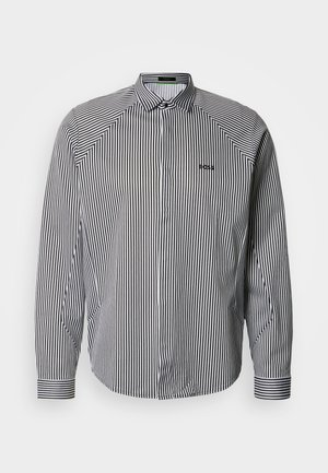 Cămașă cu dungi, nasturi, în alb și negru, prevăzută cu guler clasic, mâneci lungi și broderie discretă a logo-ului pe piept.