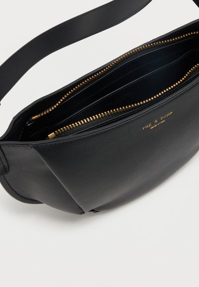 Μαύρη δερμάτινη τσάντα χιαστί με χρυστό φερμουάρ και λογότυπο "rag & bone New York", ανοιχτή για να φαίνονται τα εσωτερικά διαμερίσματα.