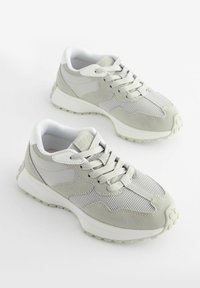 Szare buty sportowe z kombinacją materiałów siateczkowych i zamszowych, z teksturowaną podeszwą, systemem sznurowania oraz wyściełanym kołnierzem dla komfortu.