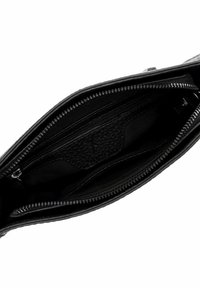 Interno di una borsa in pelle nera con numerosi scomparti con zip e tessuto testurizzato. Presenta una finitura liscia e una fodera a contrasto.