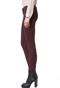 Jeans ajustados burdeos fabricados con una mezcla de algodón; cuentan con un diseño elegante, una textura suave y estilo de cinco bolsillos.