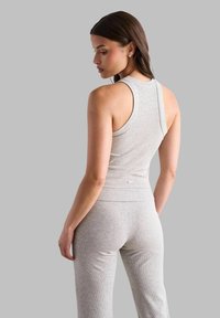 Top in cotone grigio a costine con scollo rotondo, design aderente e spalline larghe, abbinato a pantaloni a vita alta coordinati.