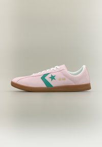 Χαμηλού προφίλ ροζ αθλητικό παπούτσι με πράσινο λογότυπο αστέρι, λευκά κορδόνια και καφέ σόλα, με την ένδειξη «All Star» στο πλάι.