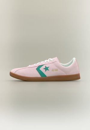 Zema profila rozā sporta kurpe ar zaļu zvaigžņu logotipu, baltiem šņorēm un brūnu zolīti, sānos ar uzrakstu "All Star".