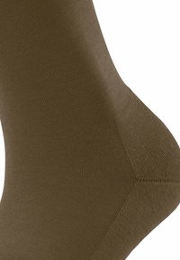 Olivgrünes Socke mit glatter Textur, geripptem Design und verstärkten Zehen- und Fersenbereichen. Nahtlose Konstruktion für mehr Komfort.