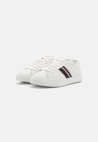 Sneakers bianchi in pelle con un design semplice, suola in gomma testurizzata e dettagli a strisce in blu, rosso e argento sui lati.