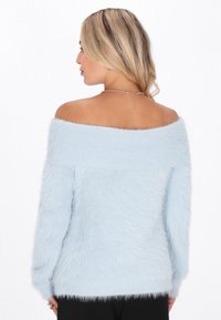 Maglione azzurro chiaro scollato sulle spalle, realizzato in materiale soffice, con dettagli a costine, maniche lunghe e una vestibilità ampia.