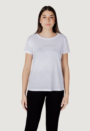 T-shirt bianco in cotone con scollatura rotonda e maniche corte. Presenta la scritta "ARMANI EXCHANGE" in un colore tonale e sottile sul petto.