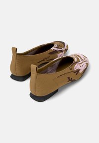 Brown slip-on shoes with a textured design, featuring floral patterns in pink and dark brown, and a low black heel at the back.