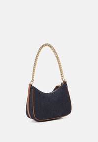 Jeansax med ett guld kedjehandtag, bruna detaljer och en böjd silhuett. Har ett dragkedjestängning och en mjuk textur.