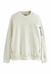 Sudadera color crema con cuello y puños acanalados, que incluye un bolsillo lateral con cremallera y tela suave y texturizada. Corte y diseño relajado.