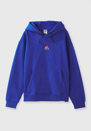 Hooded sweatshirt in vibrant blue, featuring an orange ACG logo, a kangaroo pocket, and drawstrings at the hood. Made from soft material.