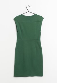 Vestido verde ajustado con mangas cortas, hecho de una tela suave. Tiene un escote redondo y costuras princesa para dar forma. Está colgado de un gancho negro.