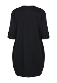 Schwarze Tunika mit lässigem Schnitt, Dreiviertel-aufgerollten Ärmeln und abgerundetem Saum. Hergestellt aus weichem, glattem Stoff mit minimalen Nähten.