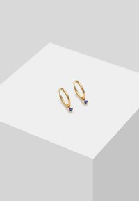Pendientes de aro dorados con un pequeño acento de piedra preciosa azul. Acabado liso con un diseño de cierre articulado.