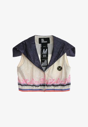 Chaleco corto sin mangas con cuello ancho oscuro, cuerpo color crema, diseño floral rosa, dobladillo a rayas y logotipo redondo negro cosido en la parte delantera.