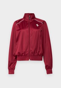 Red satin jacket with a high collar, front zipper, and ribbed cuffs. Features white accents and a small logo on the left chest.