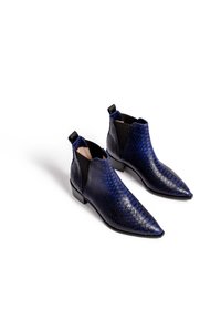 Granatowe botki za kostkę z teksturowanym, przypominającym skórę jaszczurki wzorem, spiczastym noskiem, elastycznymi panelami bocznymi oraz niskim obcasem dla wsparcia.