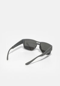 Ochelari de soare gri cu rame dreptunghiulare, lentile întunecate și brațe drepte. Textul de pe brațe adaugă detalii de brand.