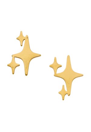 Twee metalen oorbellen in de vorm van een gouden ster met drie punten, elk voorzien van een grotere en twee kleinere sterren op een witte achtergrond.
