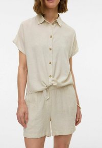 Lichtbeige, kortgemouwde, knoopsluiting shirt met een geknoopt voorste deel, gecombineerd met bijpassende shorts; gemaakt van een zachte, gestructureerde stof.