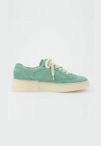 Sneakers verde in suede con una solida suola crema, punta arrotondata e lacci beige; sono caratterizzati da dettagli di cucitura lungo la parte superiore e la linguetta.