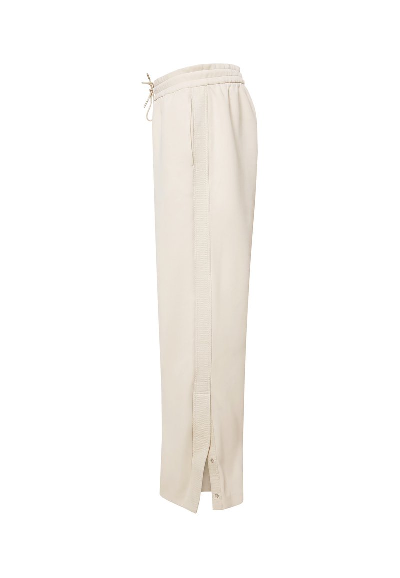 Pantalones jogger de color beige claro con cintura elástica con cordón, bolsillos laterales, raya vertical texturizada y aberturas en el tobillo con botones a presión.