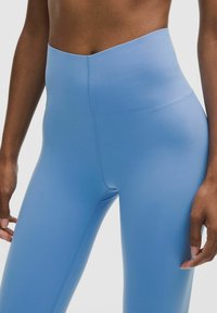 High-waisted blue leggings made of stretchy fabric, featuring a smooth texture and clean seams, suitable for active wear.