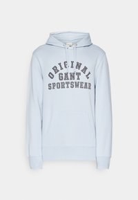 Sweat à capuche bleu clair avec poche kangourou, capuche avec cordon, et texte "ORIGINAL GANT SPORTSWEAR" en lettres capitales noires sur la poitrine.