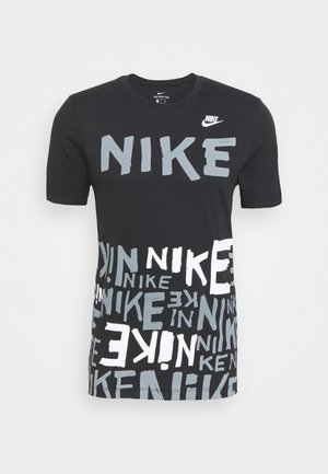 Czarny, krótki rękaw Nike T-shirt z dużym napisem "NIKE" na klatce piersiowej oraz wieloma mniejszymi, rozproszonymi logo Nike w białym i szarym kolorze na dolnej połowie.