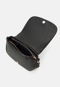 Svart läder crossbody-väska med en texturerad yta, guldfärgad hårdvara, ficka med dragkedja och säker knappstängning på framsidan.