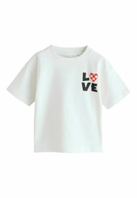 Bela majica s kratkimi rokavi, ki prikazuje besedo "LOVE" v črnem tisku in rdeče srce s karirastim vzorcem na levi strani.