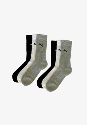 Four pairs of crew socks: two black, one white, and one gray. Ribbed design with contrast logos. Made from blended fabric for comfort.