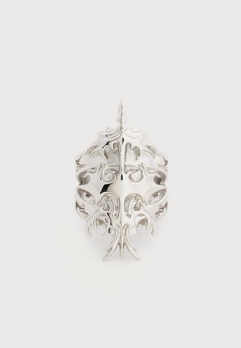 Πολυτελές ασημένιο δαχτυλίδι με συμμετρικό, περίπλοκο φιλγκρέ σχέδιο που μοιάζει με φύλλα και ανθικά μοτίβα σε απλό φόντο.