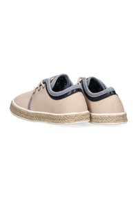 Zapatos de lona beige con detalles en azul marino y suela de yute trenzado. Punta redondeada, diseño con cordones y forro de terciopelo. Vista trasera mostrada.