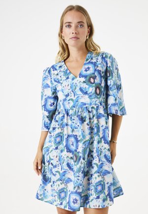 Bloemrijk jurkje met een V-hals, voluminous mouwen en een gathered taille. De stof heeft een blauw en groen aquarelpatroon met geometrische vormen.
