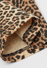 Tejido de estampado de leopardo con textura acanalada en marrón y negro. El dobladillo presenta un detalle de costura en hilo negro.
