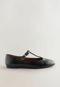 Musta nahkainen ballet-tossu, jossa on T-nauhat, pyöreä kärki ja pieni kultainen solki. Sileä pinta ja minimalistinen tyyli.