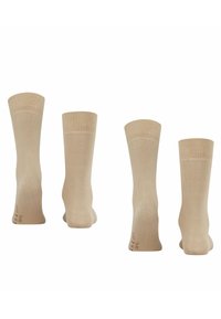 Calzini in cotone beige mostrati da diverse angolazioni. Texture liscia, polsini a coste, lunghezza a metà polpaccio, con un discreto marchio sulla suola.
