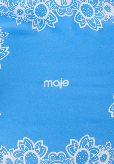 Μπλε ύφασμα με λευκά λουλουδάτα περιθώρια και τη λέξη «maje» στο κέντρο με πεζά γράμματα.