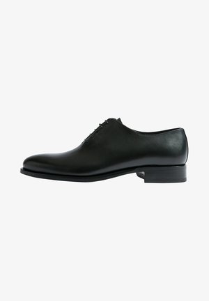 Schwarze Leder-Halbschuhe mit glatter Textur, runder Zehenform, Schnürung und niedrigem, gestapeltem Absatz. Schlichtes Design ohne sichtbare Muster.