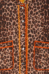 Leopardprint jasje in beige en bruin met oranje golvende rand, zilveren drukknoopjes en twee voorzakken met vergelijkbare randdetails.