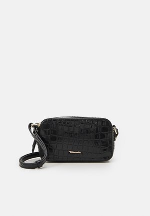 Sac bandoulière noir en faux cuir brillant avec une texture crocodile. Doté d'une bandoulière détachable et d'une fermeture à glissière. Accents en matériel doré.